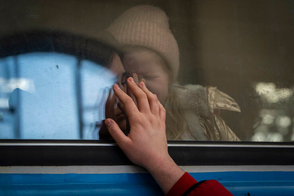 Ucranianos desplazados en un tren rumbo a Polonia se despiden en Leópolis, Ucrania, el martes 22 de marzo de 2022. Más de 5 millones de refugiados han huido de Ucrania desde que inició la guerra de Rusia, informó la agencia de refugiados de la ONU el 20 de abril de 2022. Es la mayor crisis de refugiados en Europa desde la Segunda Guerra Mundial. (AP Foto/Bernat Armangue, File)