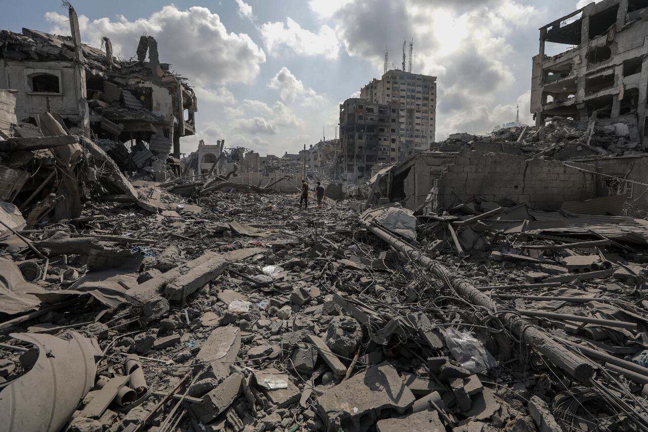 Gaza (---), 10/10/2023.- Palestinians walk among the rubble in the destroyed Al-Ramal neigbourhood following an Israeli air strike in Gaza City, 10 October 2023. More than 700 people have been killed and around 4,000 have been injured according to the Palestinian Ministry of Health, after Israel started bombing the Palestinian enclave in response to an attack carried out by the Islamist movement Hamas on 07 October. More than 3,000 people, including 1,500 militants from Hamas, have been killed and thousands injured in Gaza and Israel since 07 October, according to Israeli military sources and Palestinian officials. EFE/EPA/MOHAMMED SABER
