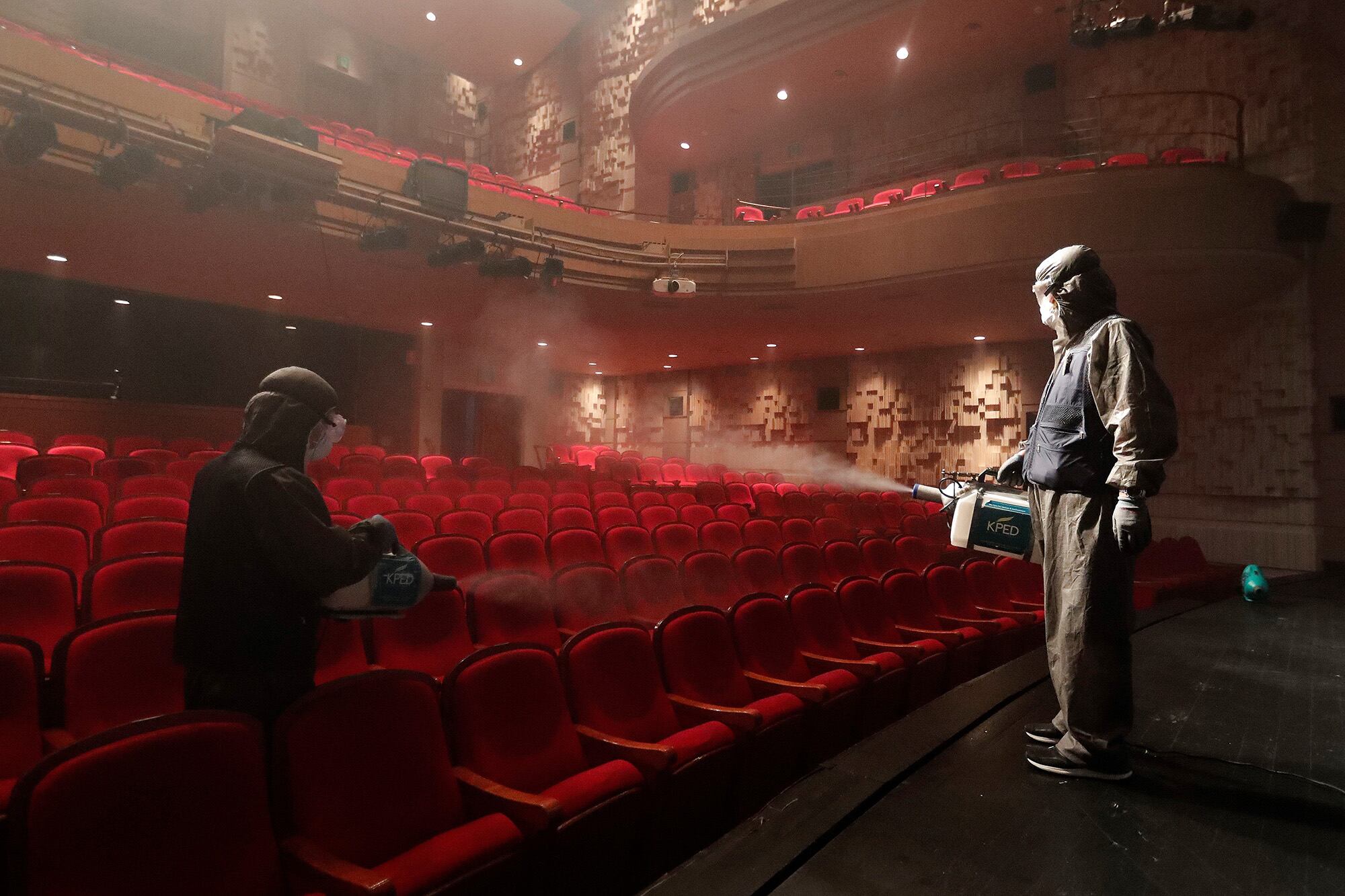 Personal de sanidad desinfectan un teatro en el Centro Sejong en Seúl.