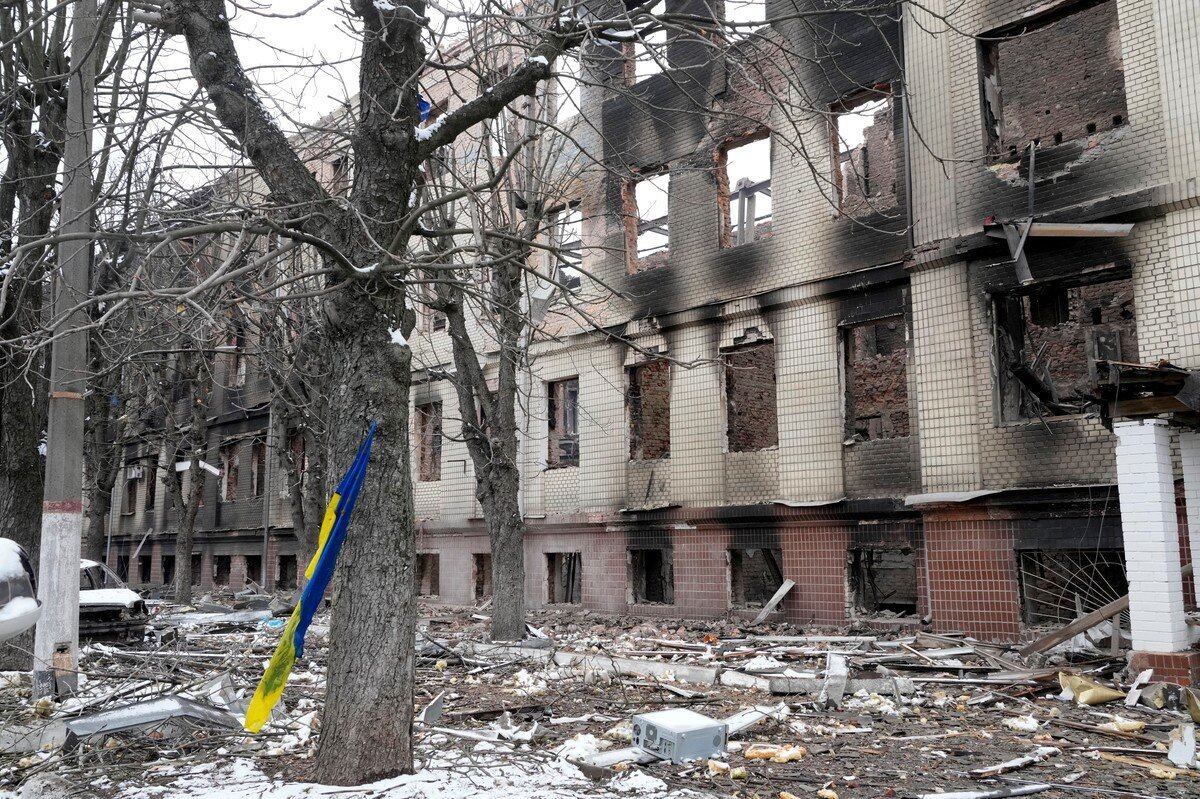 Una bandera nacional ucraniana se balancea en un árbol junto a un edificio de alojamiento destruido cerca de un puesto de control en Brovary, en las afueras de Kiev, Ucrania, el martes 1 de marzo de 2022.