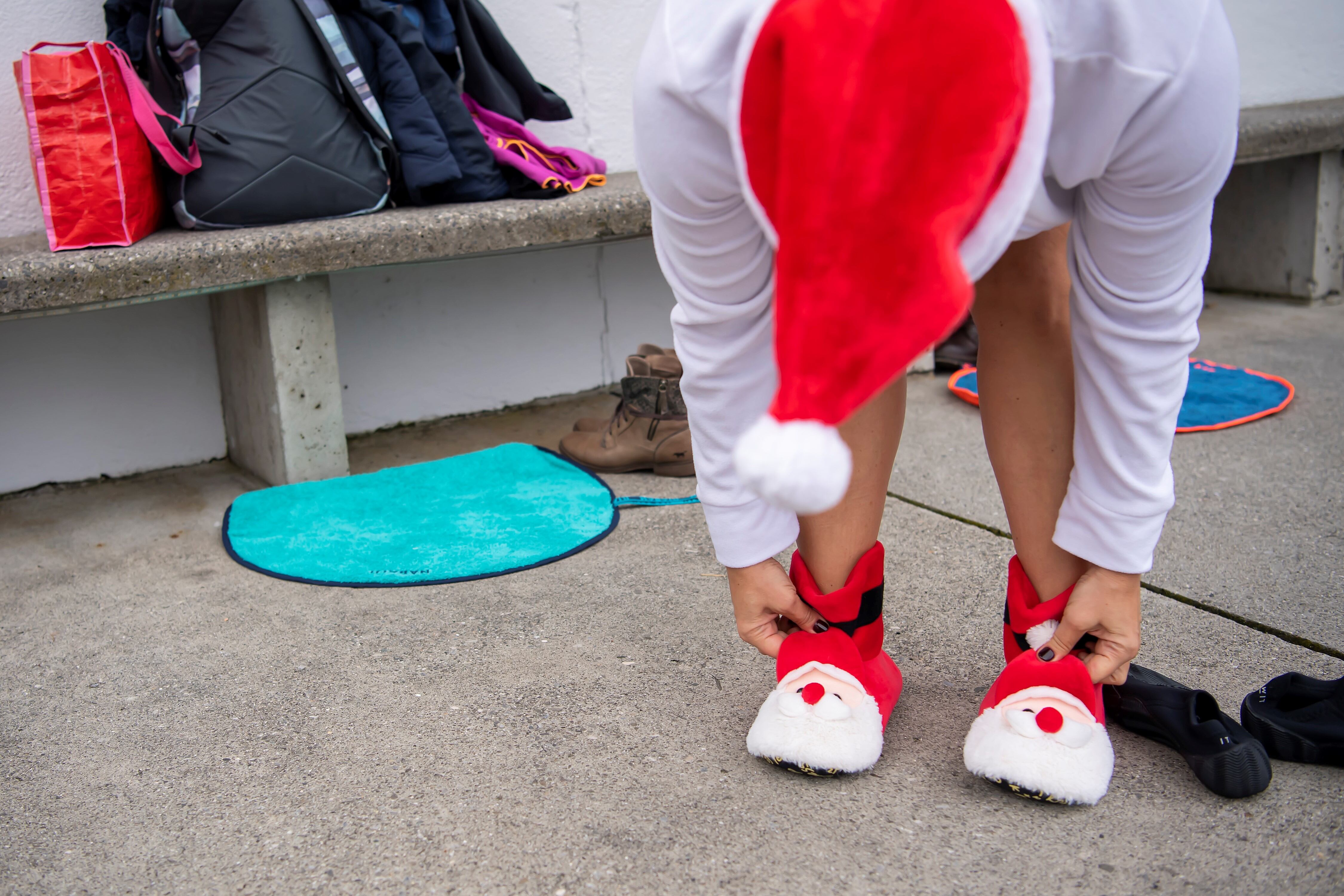 Una mujer que llevaba un sombrero y zapatos de Santa Claus, se prepara para participar en un baño de Nochebuena en agua de 8 grados Celsius, en el lago Leman en Bains des Paquis, en Ginebra.