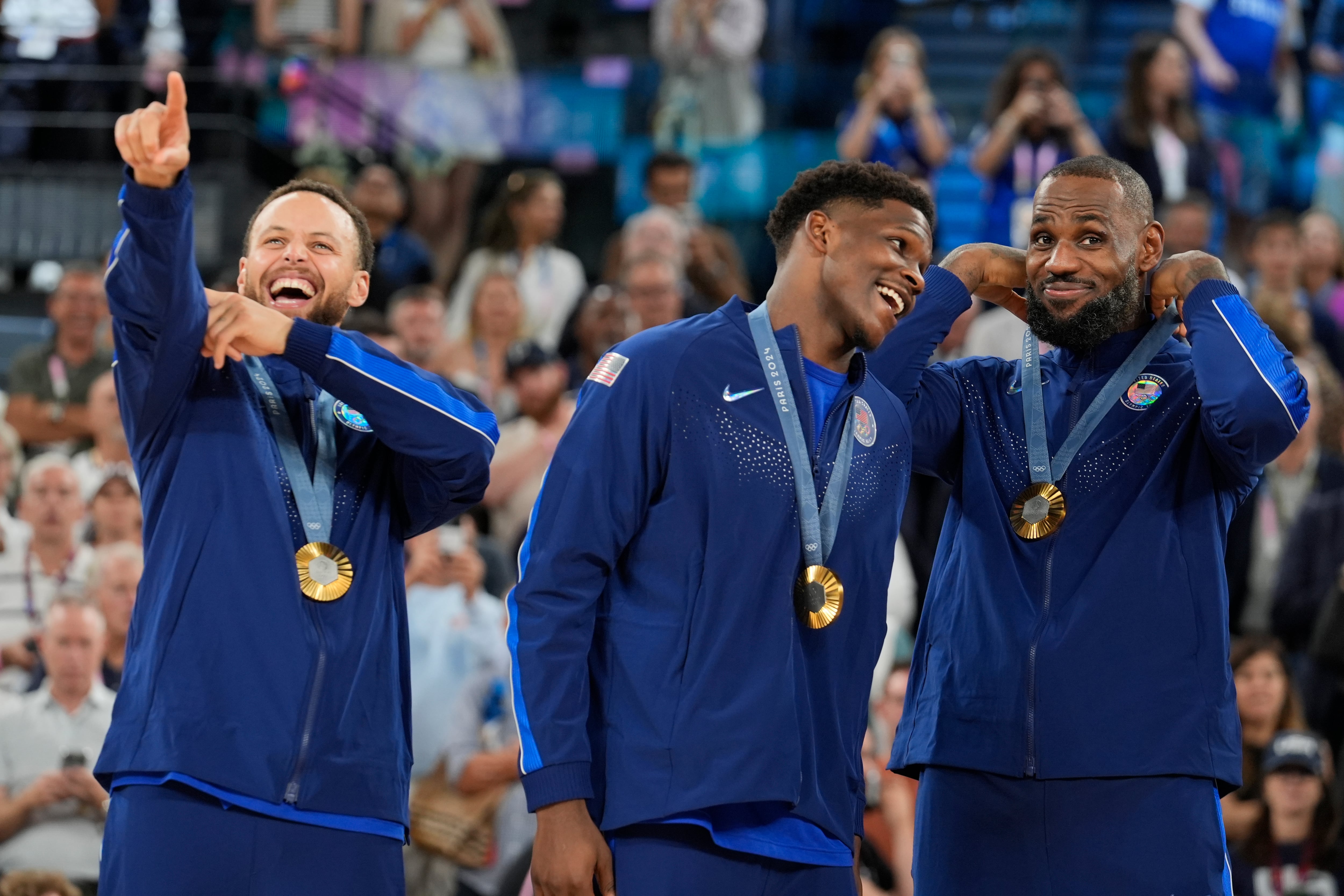 De izquierda a derecha, los estadounidenses Stephen Curry, Anthony Edwards y LeBron James celebran tras vencer a Francia en la final del baloncesto masculino de los Juegos Olímpicos de París, el sábado 10 de agosto de 2024. (AP Foto/Rebecca Blackwell)