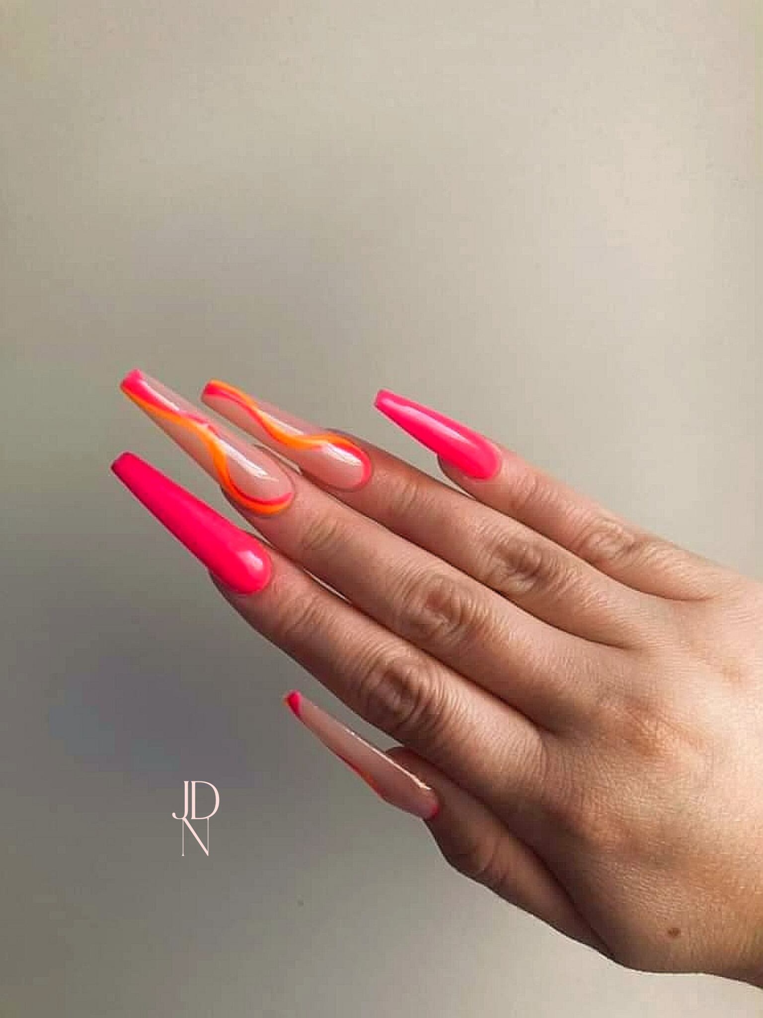 Uñas largas con diseño "wavy" en fucsia y naranja. 