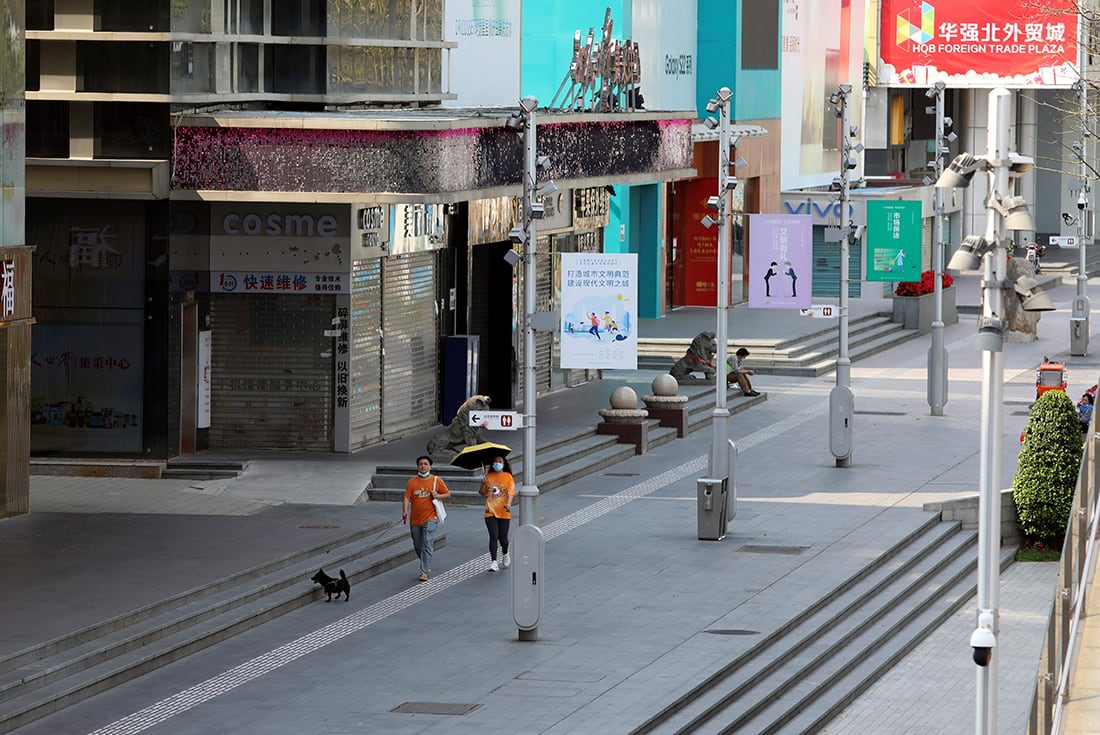 Los residentes pasean a su perro frente a tiendas cerradas en el área de Huaqiangbei, el mercado de productos electrónicos más grande del mundo, en Shenzhen, provincia de Guangdong, en el sur de China. 