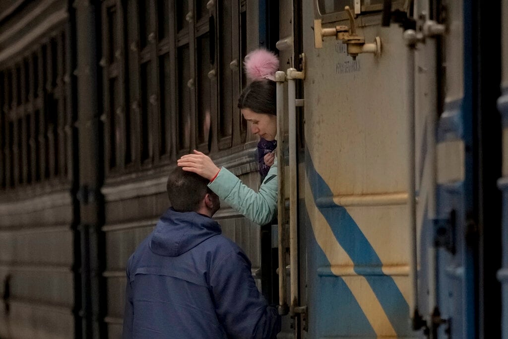 Una mujer que sostiene a un niño en un tren con rumbo a Leópolis se despide de un hombre, en Kiev. Foto: AP / Vadim Ghirda