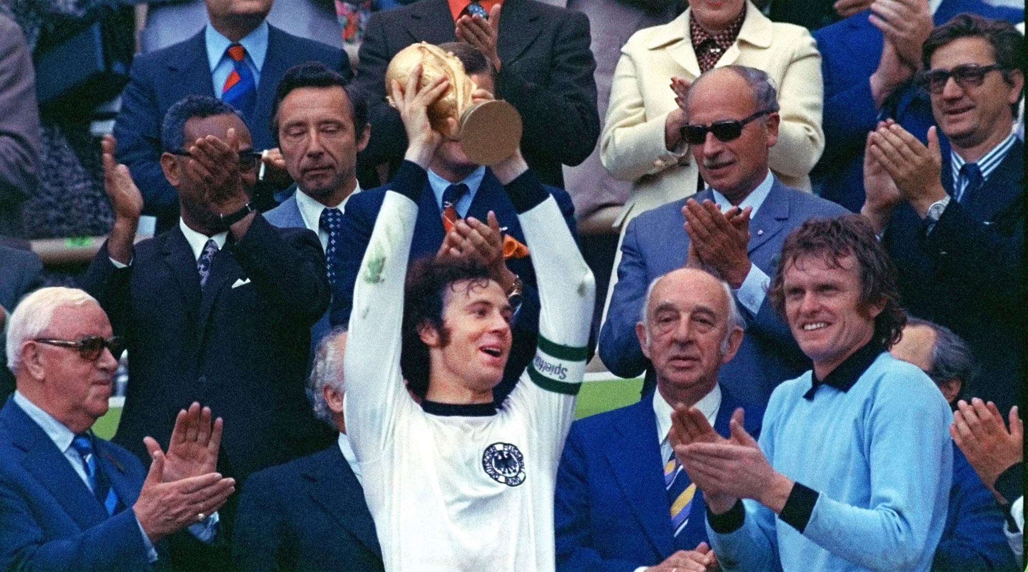 ARCHIVO - El capitán de Alemania Occidental Franz Beckenbauer (centro) alza el trofeo de campeón del Mundial de 1974, el 7 de julio de 1974, en Múnich. Beckenbauer ha fallecido. Tenía 79 años. (AP Foto/stf, archivo)