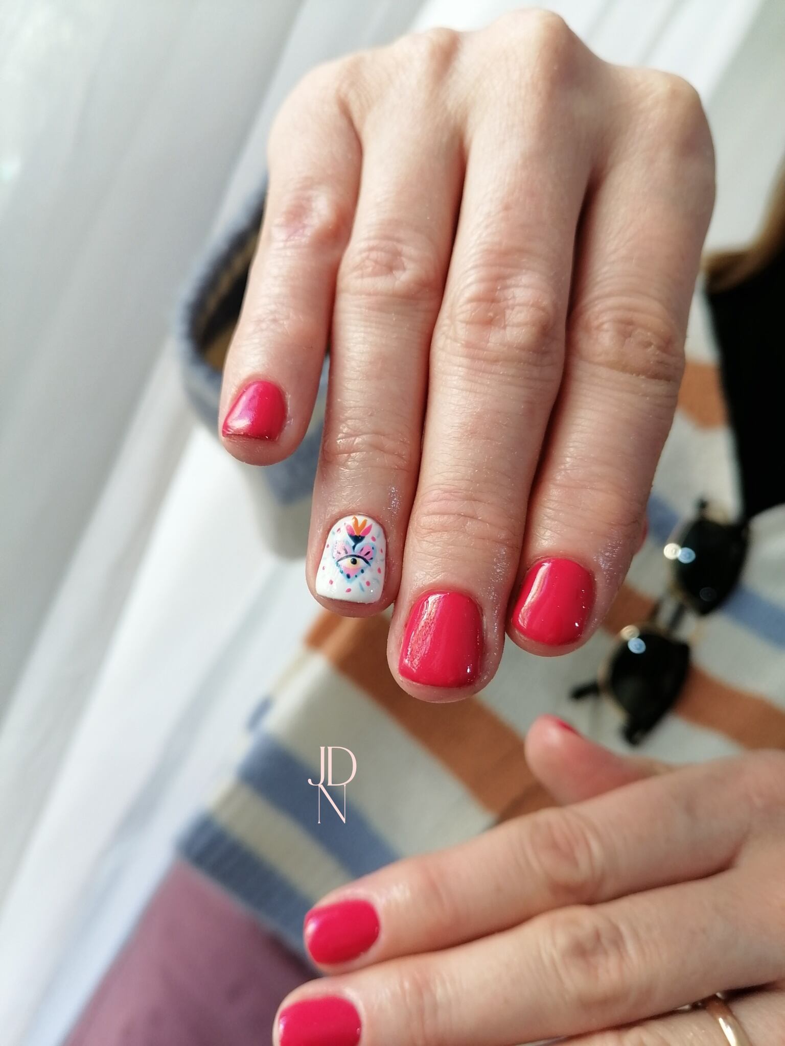 Uñas en fucsia oscuro con diseño solo en una de ellas.