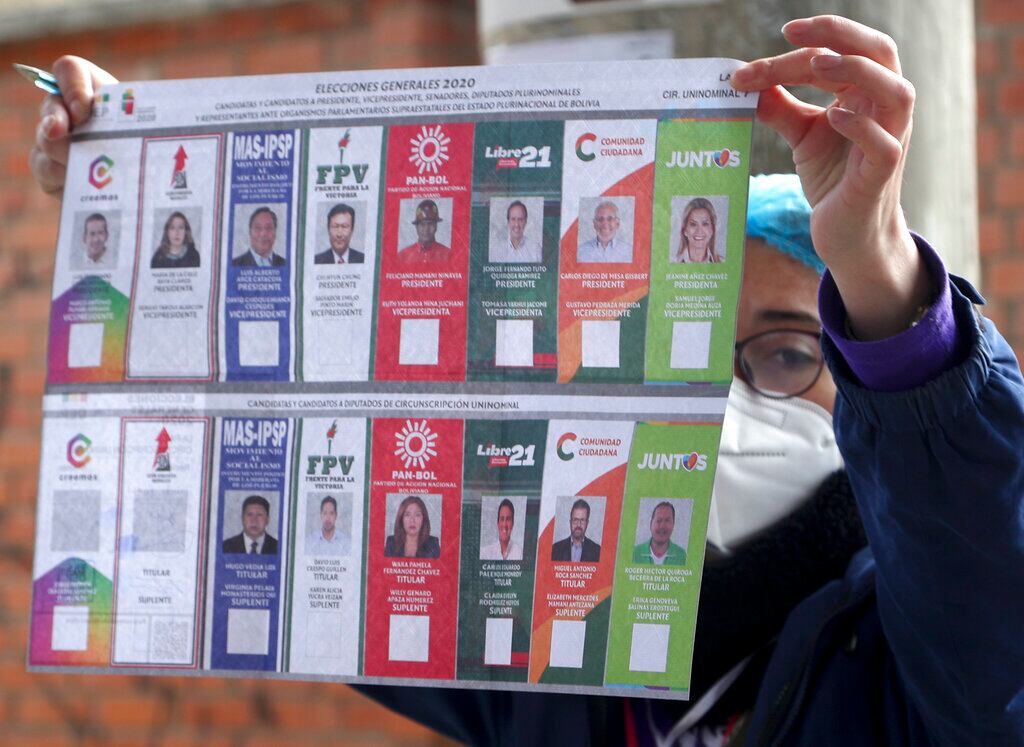 Un funcionario electoral muestra las papeletas a un votante en un colegio electoral durante las elecciones generales en la capital de Bolivia.