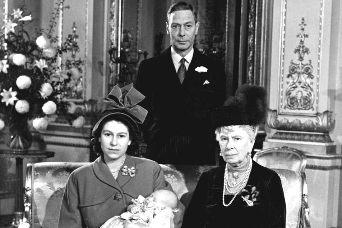 La princesa Isabel de Gran Bretaña, más tarde reina Isabel II, sostiene a su hijo, el príncipe Carlos, en el Palacio de Buckingham, después de su bautizo, en Londres, el 15 de diciembre de 1948. A la derecha está sentada su abuela, la reina María, madre de su padre, el rey Jorge VI (Pool AP, Archivo)