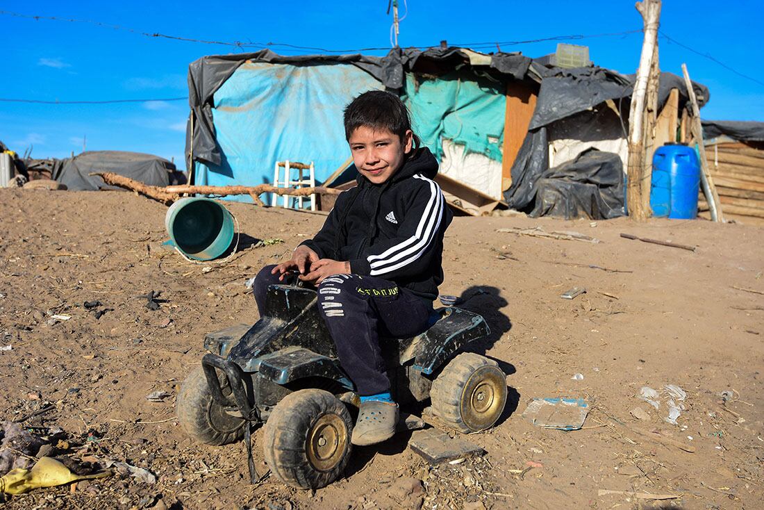 Kevin tiene 9 años y vive en un asentamiento al costado de un basural. Creció jugando con juguetes rotos. Reside en una precaria casa de nylon y cartones que construyeron su mama con su abuela - 