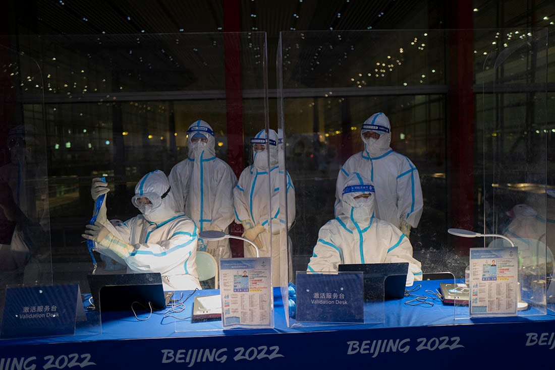 Personal equipado con trajes de protección trabajan en un puesto de validación de credenciales en el Aeropuerto Internacional de Beijing. 
Foto: AP