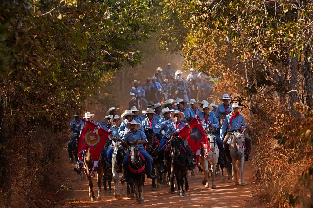 Personas a caballo desfilan al término de la tradición religiosa "Fiesta del Divino Espíritu Santo", en la región rural de Pirenópolis, en el estado de Goias, Brasil, el sábado 28 de mayo de 2022. (AP Foto/Eraldo Peres)