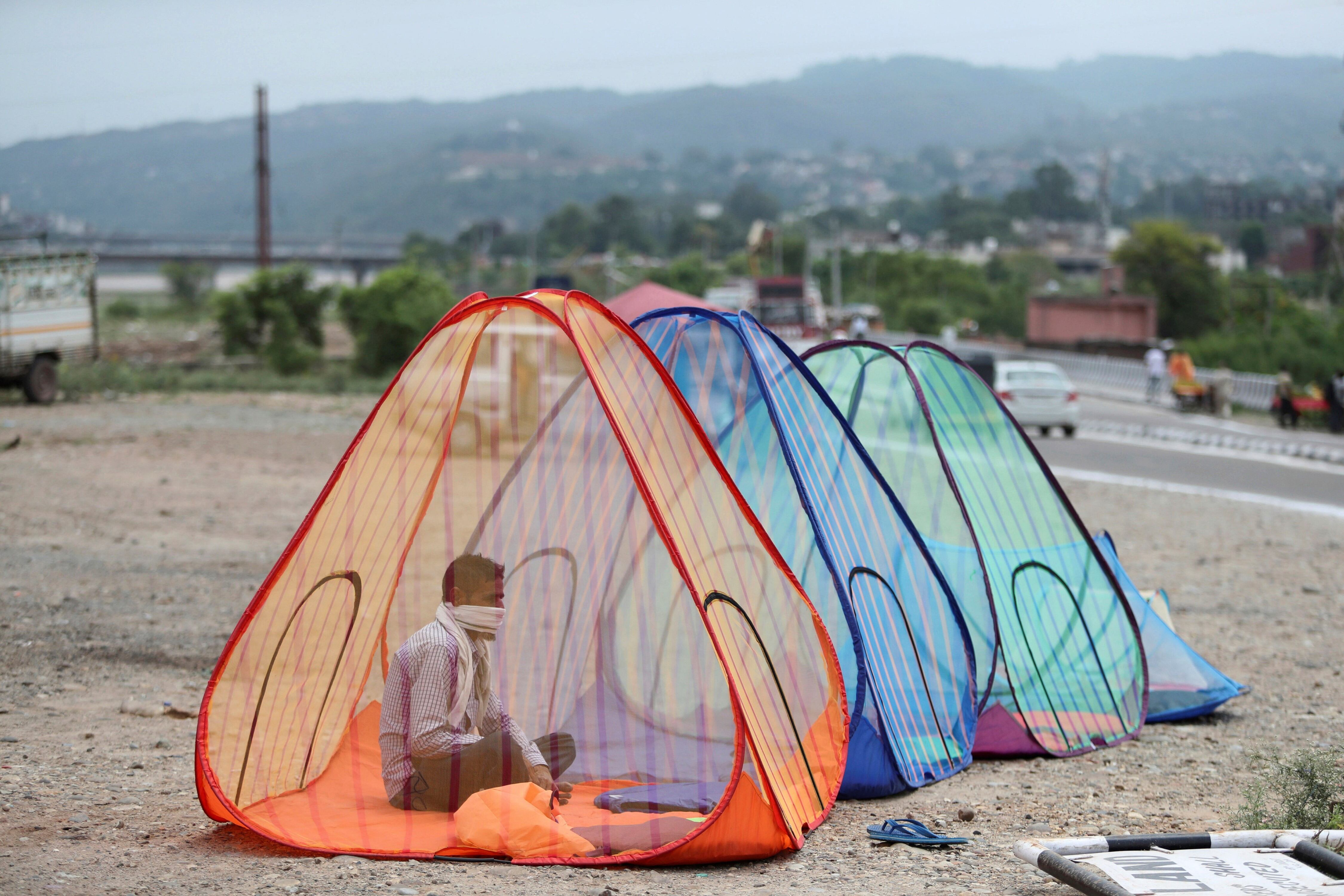 Un vendedor ambulante ofrece mosquiteros al publico en una calle de Jammu, India.