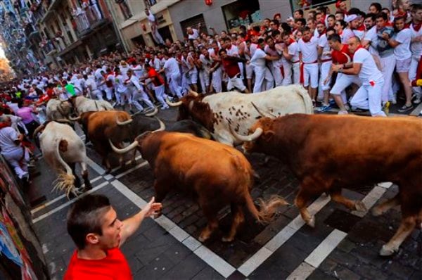 Juerguistas huyen de un toro en una de las corridas por el festival de San Fermín, en Pamplona, España, el domingo 7 de julio de 2013. (Foto AP/Alvaro Barrientos)