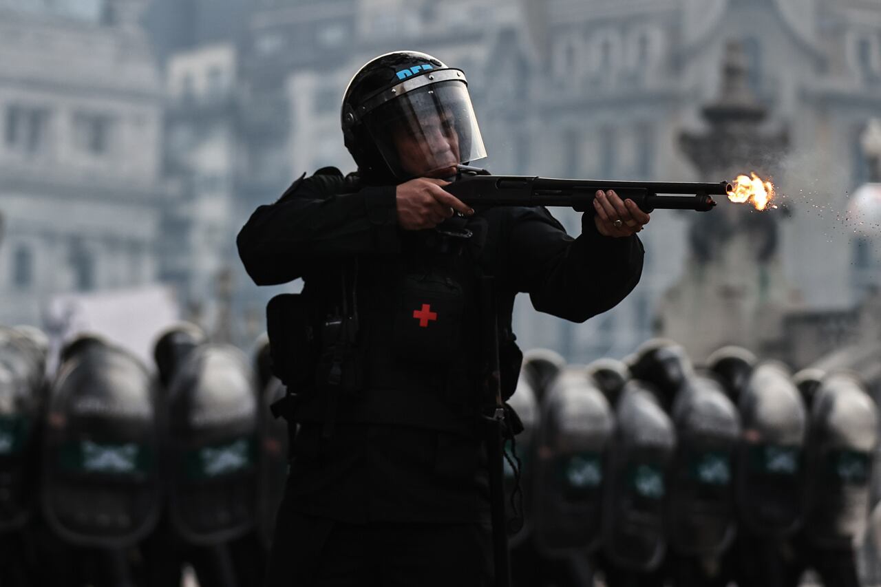 Policías disparan gases lacrimógenos durante enfrentamientos entre la policía y personas que protestan a las afueras del senado durante un debate sobre la ley de Bases. Foto: EFE / Juan Ignacio Roncoroni