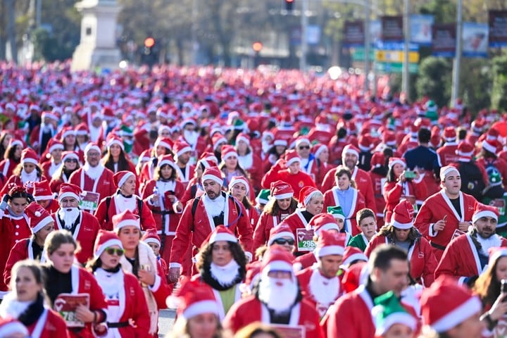 Miles de corredores vestidos de Papá Noel participan en esta tradicional Carrera de Navidad, que alcanza este año su XIII edición, en Madrid. Foto: EFE