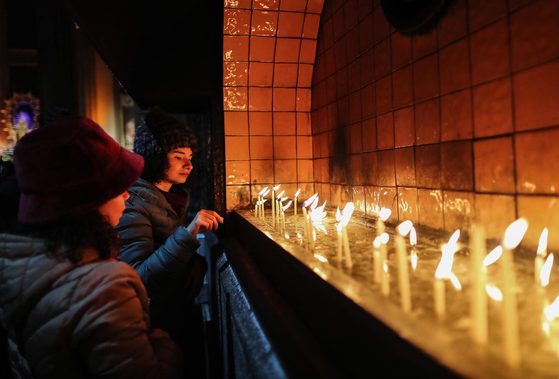 Las mujeres encienden velas mientras asisten a la Misa de Navidad en la Iglesia de San Antuan en Estambul, Turquía, el 24 de diciembre de 2022. Aunque Turquía es un país predominantemente musulmán, la temporada navideña es la principal temporada de compras mientras los turcos se preparan para las celebraciones de Nochevieja donde preparan cenas especiales e intercambio de regalos (Turquía, Estambul). Foto: EFE/EPA/ERDEM SAHIN