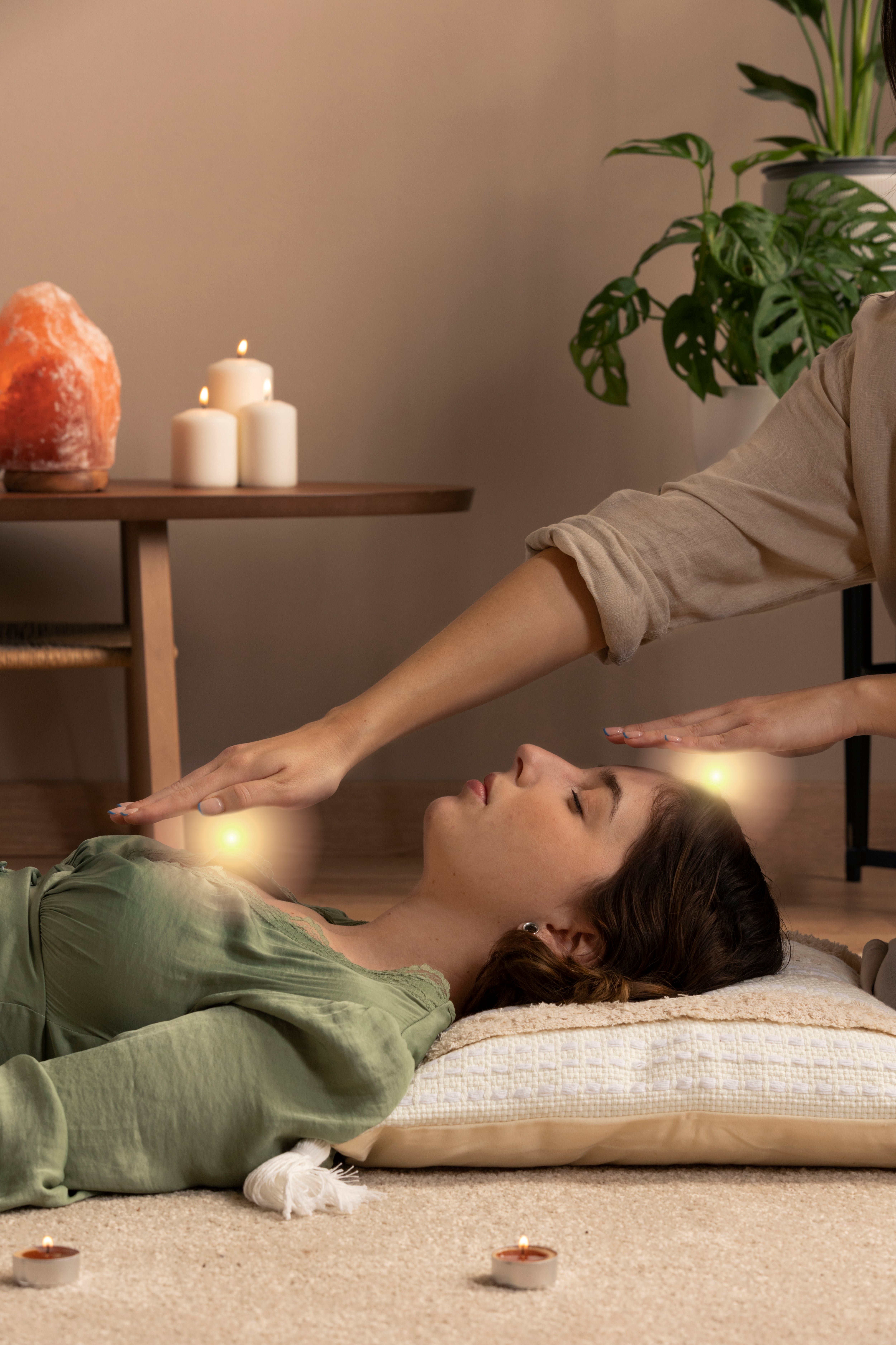 Profile view of a cute young woman getting her energy balanced at a reiki session in a health clinic and spa