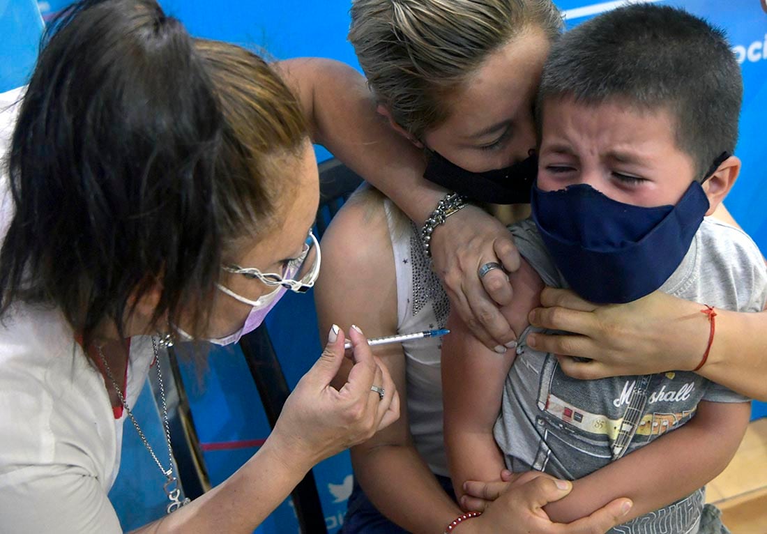 Nadia Chávez junto a su hijo Lían (8). en el Centro de Vacunación del Estadio Ribosqui en Maipú. donde la enfermera: Lorena Sánchez le coloca la tercera dosis de refuerzo de vacuna contra el Covid 19. Foto; Orlando Pelichotti