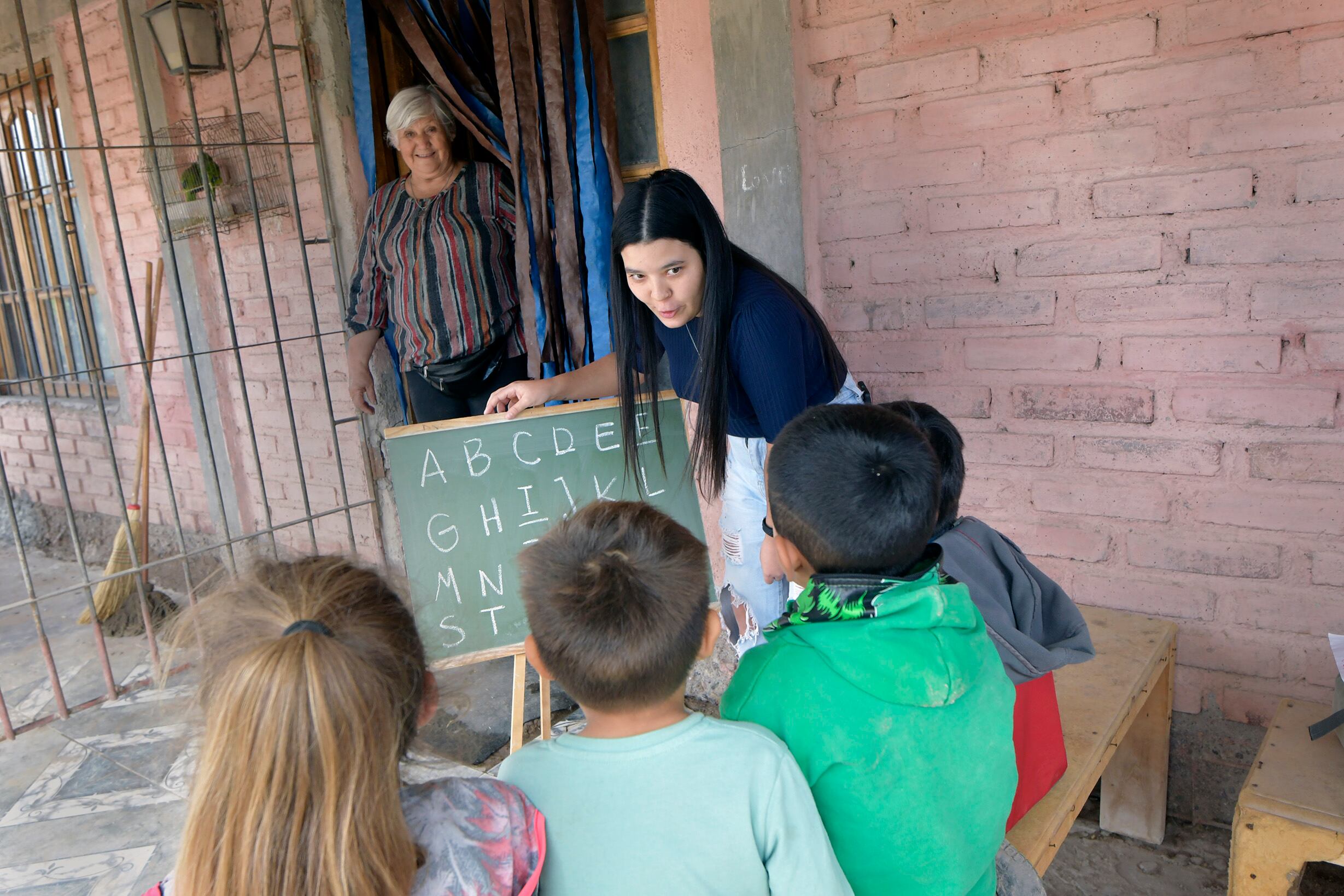 Momentos del dicatod de las clases, detrás Juanita con su infinita sonrisa. Foto: Orlando Pelichotti/ Los Andes