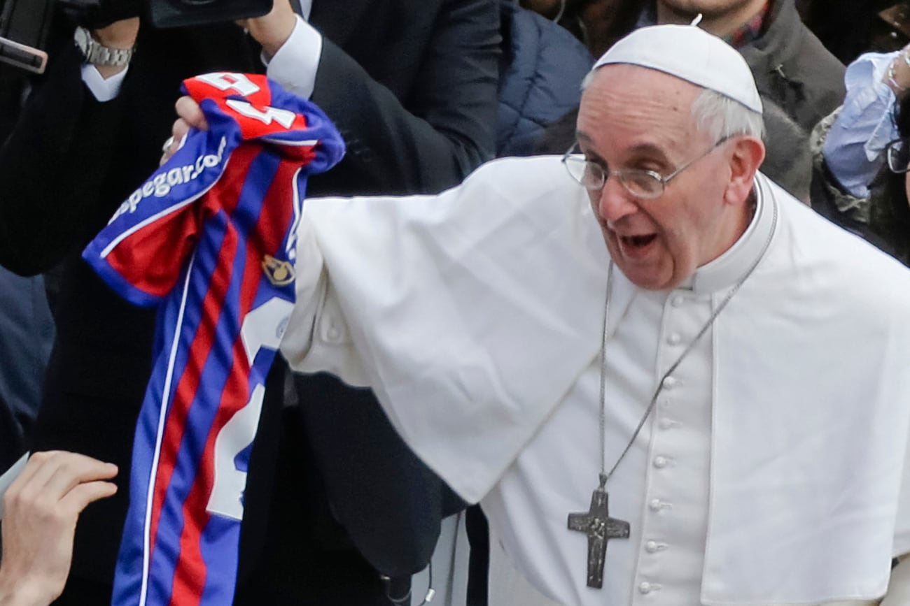 El Papa Francisco sostiene una camiseta de San Lorenzo, el equipo de fútbol de Buenos Aires, que le entregó un fiel al final de la misa de Pascua en la Plaza de San Pedro en el Vaticano, el domingo 31 de marzo de 2013. (AP)