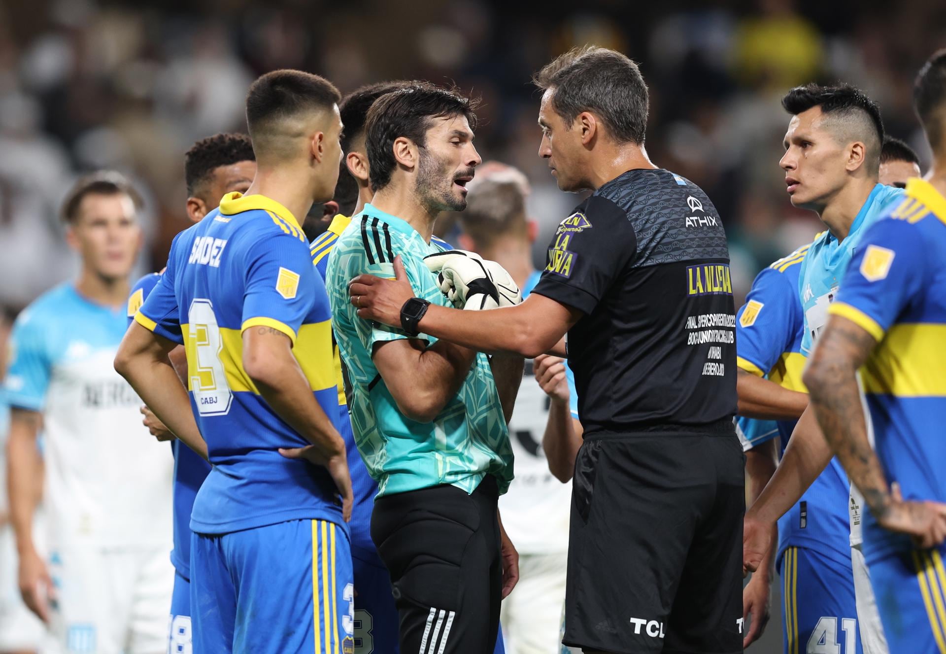 Javier García (C), portero de Boca Juniors, discute con el árbitro Fernando Rapallini durante el último partido de fútbol de la Supercopa Argentina entre Boca Juniors y Racing Club en Al Ain, Emiratos Árabes Unidos. Foto: EFE/EPA/ALI HAIDER