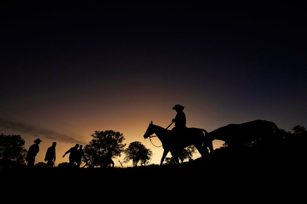 Esta fotografía muestra la silueta de una persona a caballo en el término de la tradición religiosa "Fiesta del Divino Espíritu Santo" en Pirenópolis, en el estado de Goias, Brasil, el sábado 28 de mayo de 2022. (AP Foto/Eraldo Peres)