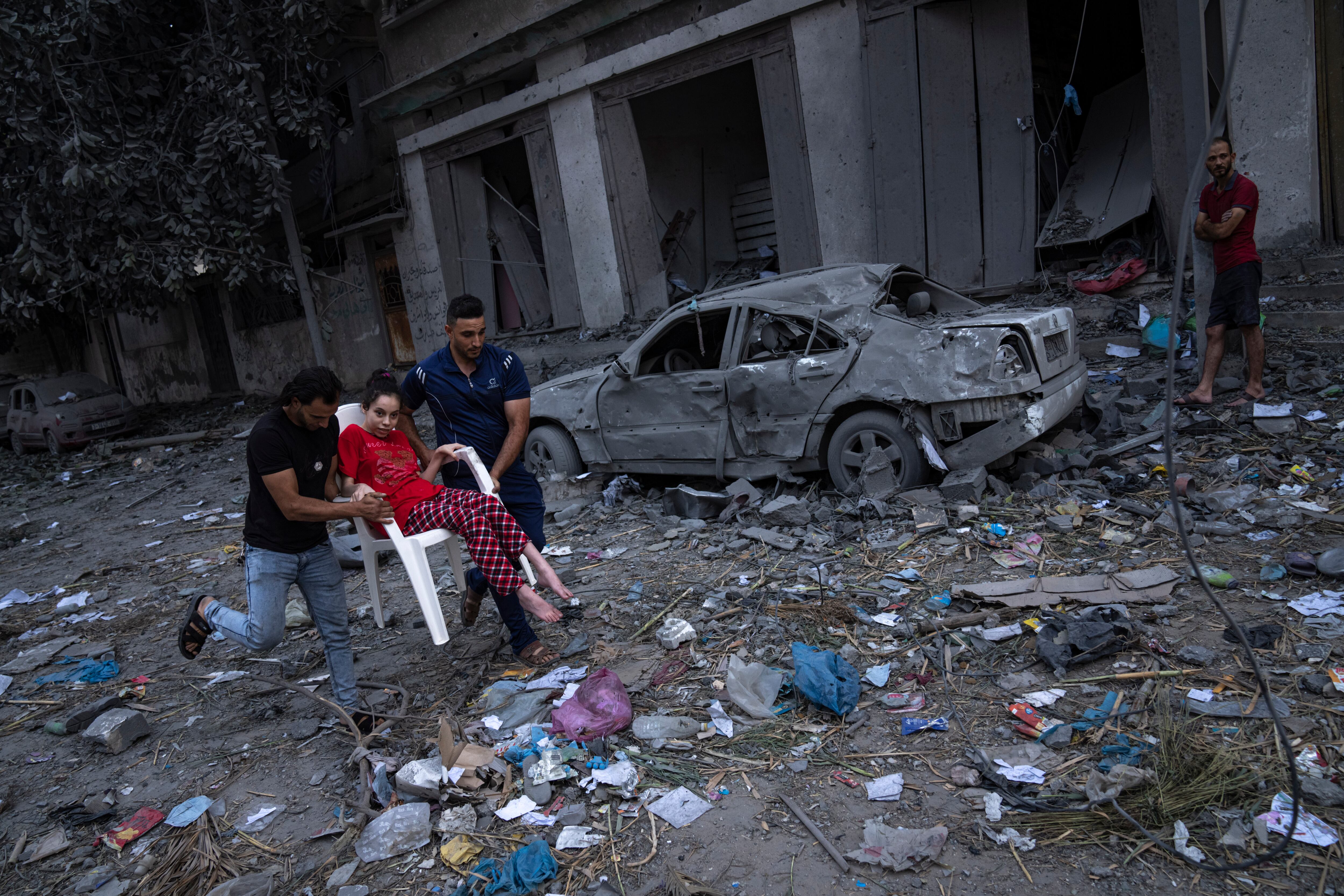 Palestinos caminan entre las ruinas tras ataques aéreos israelíes que arrasaron parte de un vecindario de la Ciudad de Gaza, el 10 de octubre de 2023. (AP Foto/Fatima Shbair)