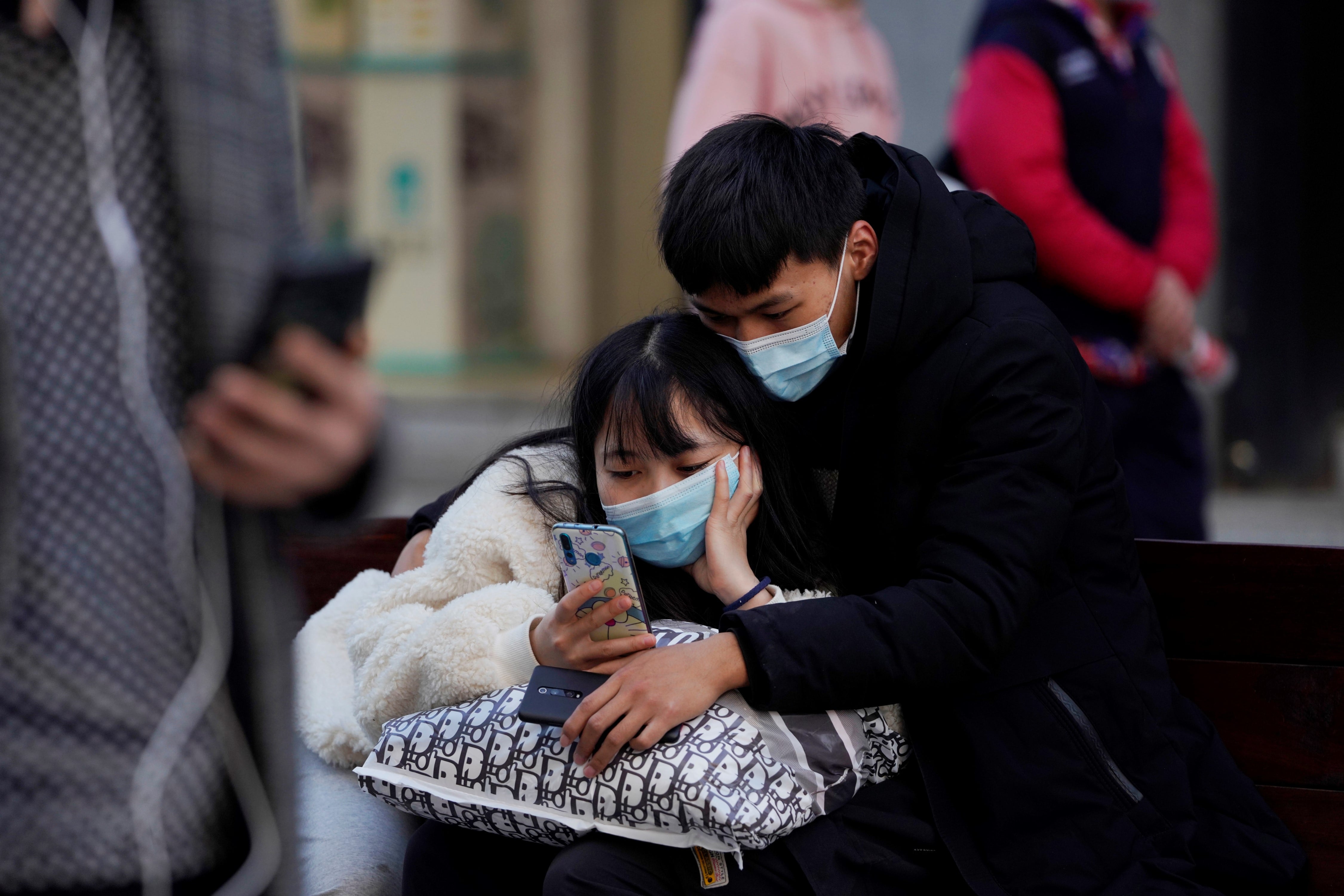 Ciudadanos de Wuhan, provincia china de Hubei, se protegen con mascarillas ante un posible rebrote del coronavirus en el país. 