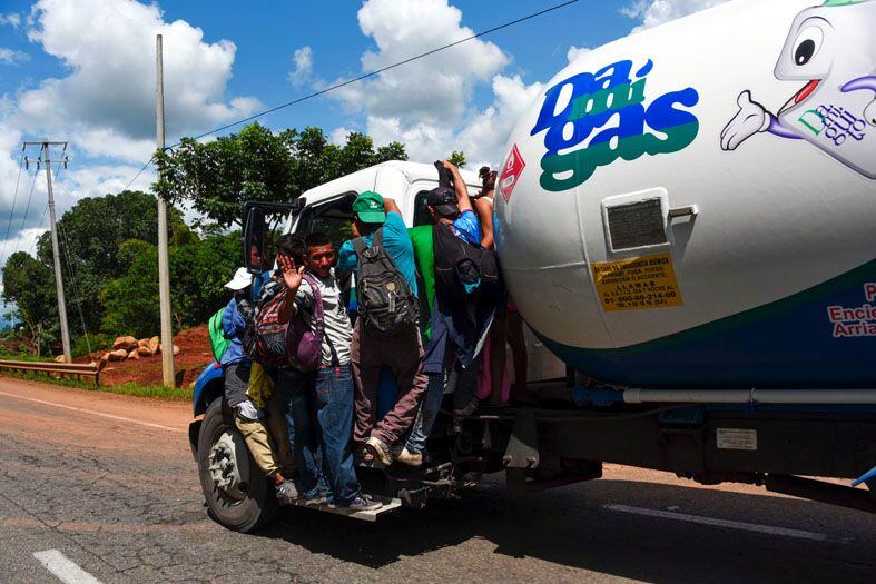 
Migrantes | Los migrantes hondureños que se encuentran en el estribo de un camión, participan en una caravana que se dirige a los Estados Unidos, en las afueras de Tapachula/AFP
   