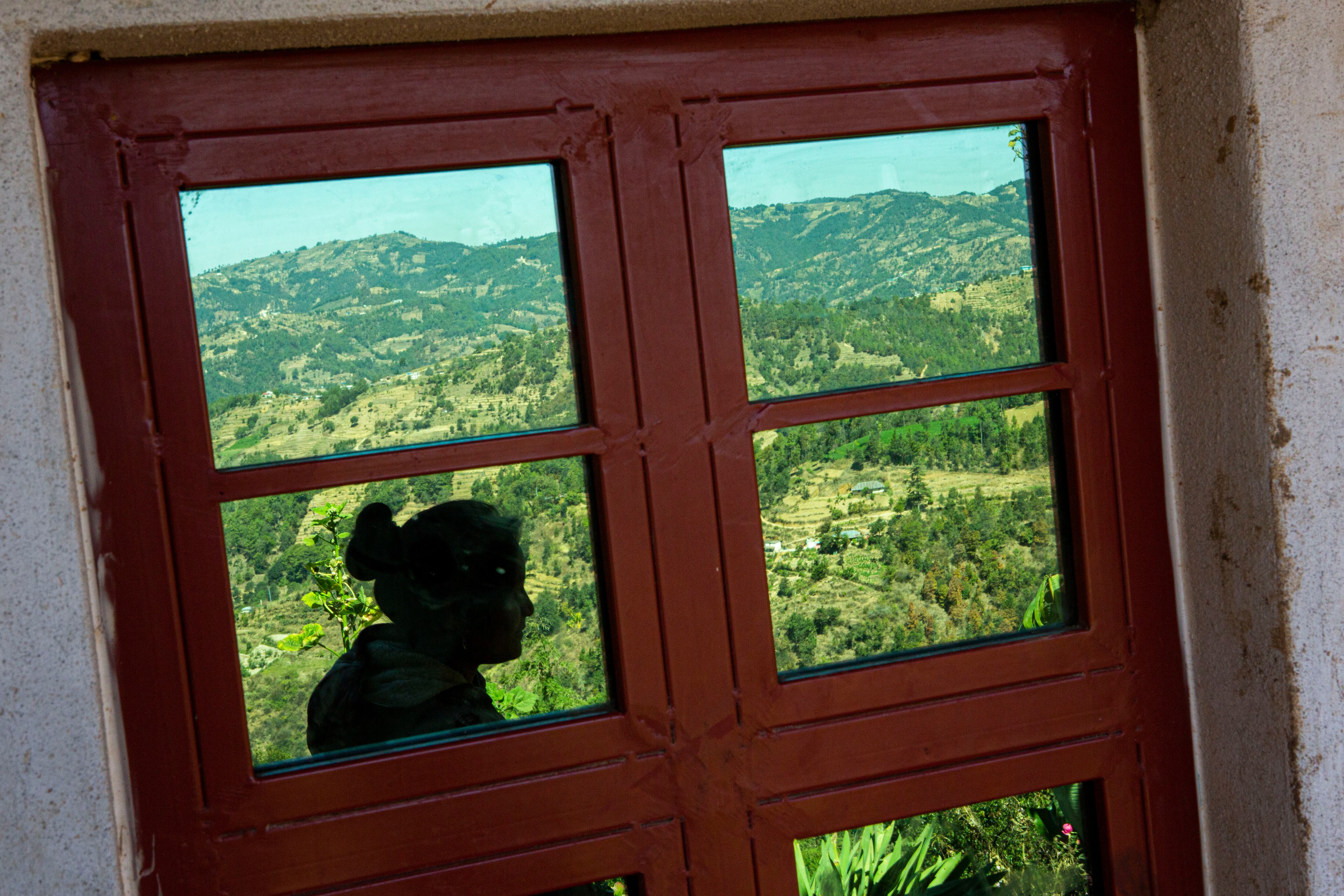 La silueta de Saidy Aguilón se refleja en una ventana de una casa en Comitancillo, Guatemala, el 27 de enero de 2021. Aguilón cree que su esposo es uno de los cadáveres calcinados hallados en un estado del norte de México