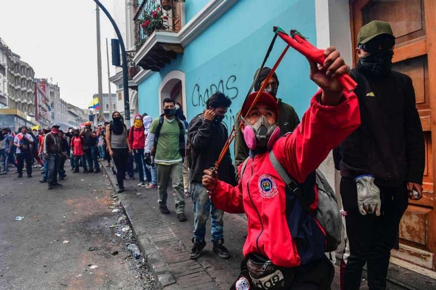 
Foto: AFP | Un manifestante usa una honda para arrojar una piedra a la policía antidisturbios durante los enfrentamientos en Quito.
   