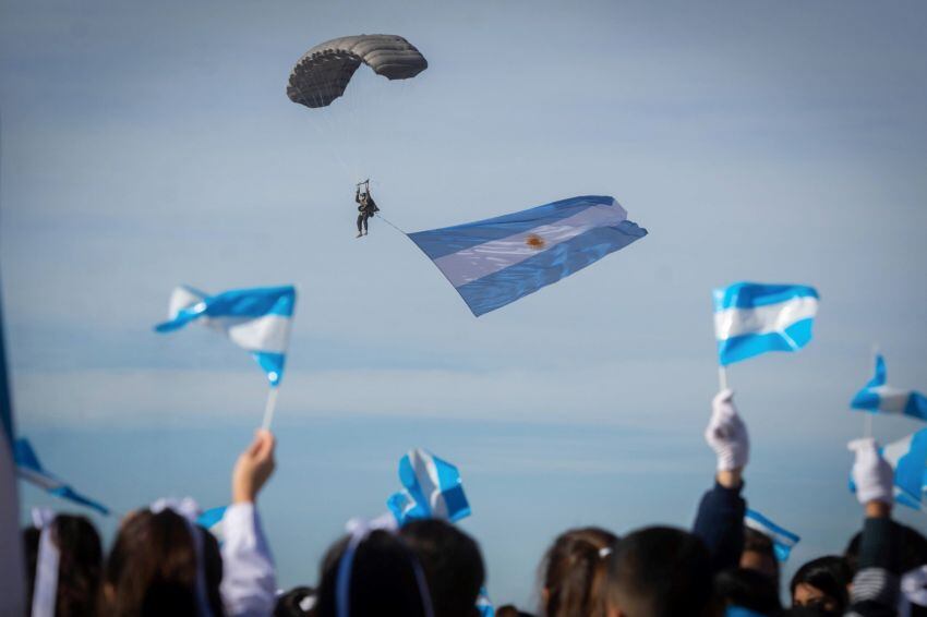 
Saludo. Los alumnos agitan sus banderines sobre la pista mientras observan el descenso de un paracaidista que porta la enseña nacional | Ignacio Blanco / Los Andes
   