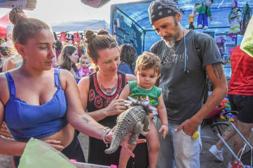 
Regalo. Una vendedora le muestra un dinosaurio a Cris, junto a sus padres Julieta y Alejandro. | Mariana Villa / Los Andes
   