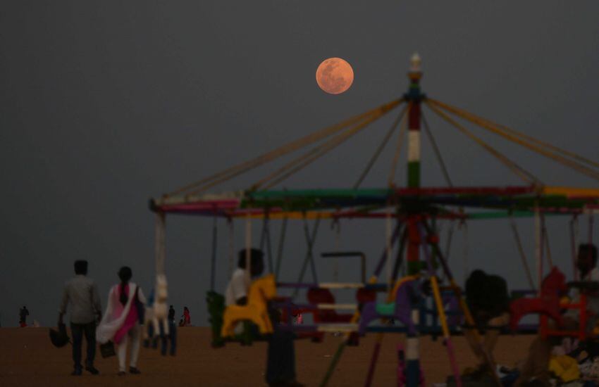 
    El 19 de febrero de 2019 se eleva una 'Super Luna de Nieve' a medida que los residentes disfrutan de la velada en la playa Marina en Chennai. Foto: AFP
   