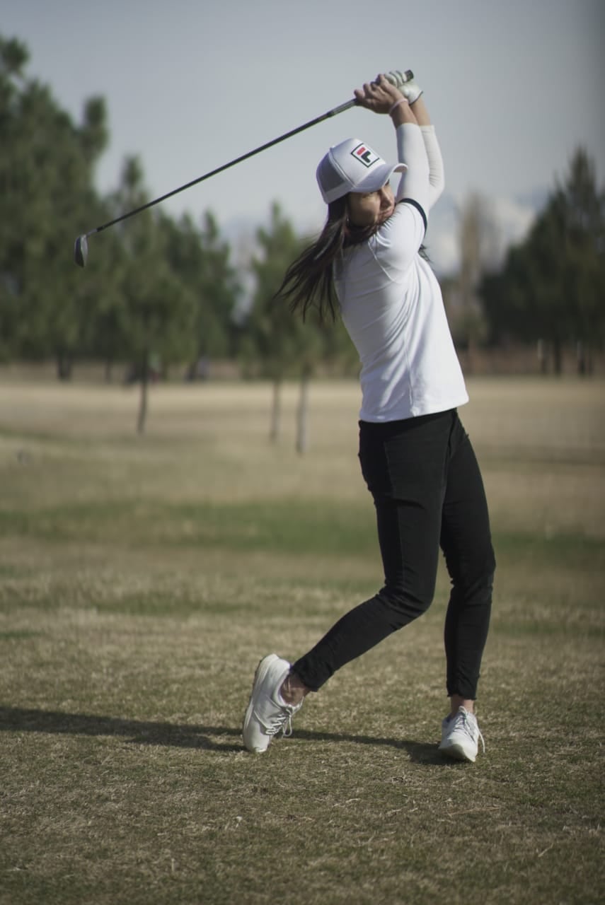 Con un estilo único, esta golfista busca su hoyo en uno.