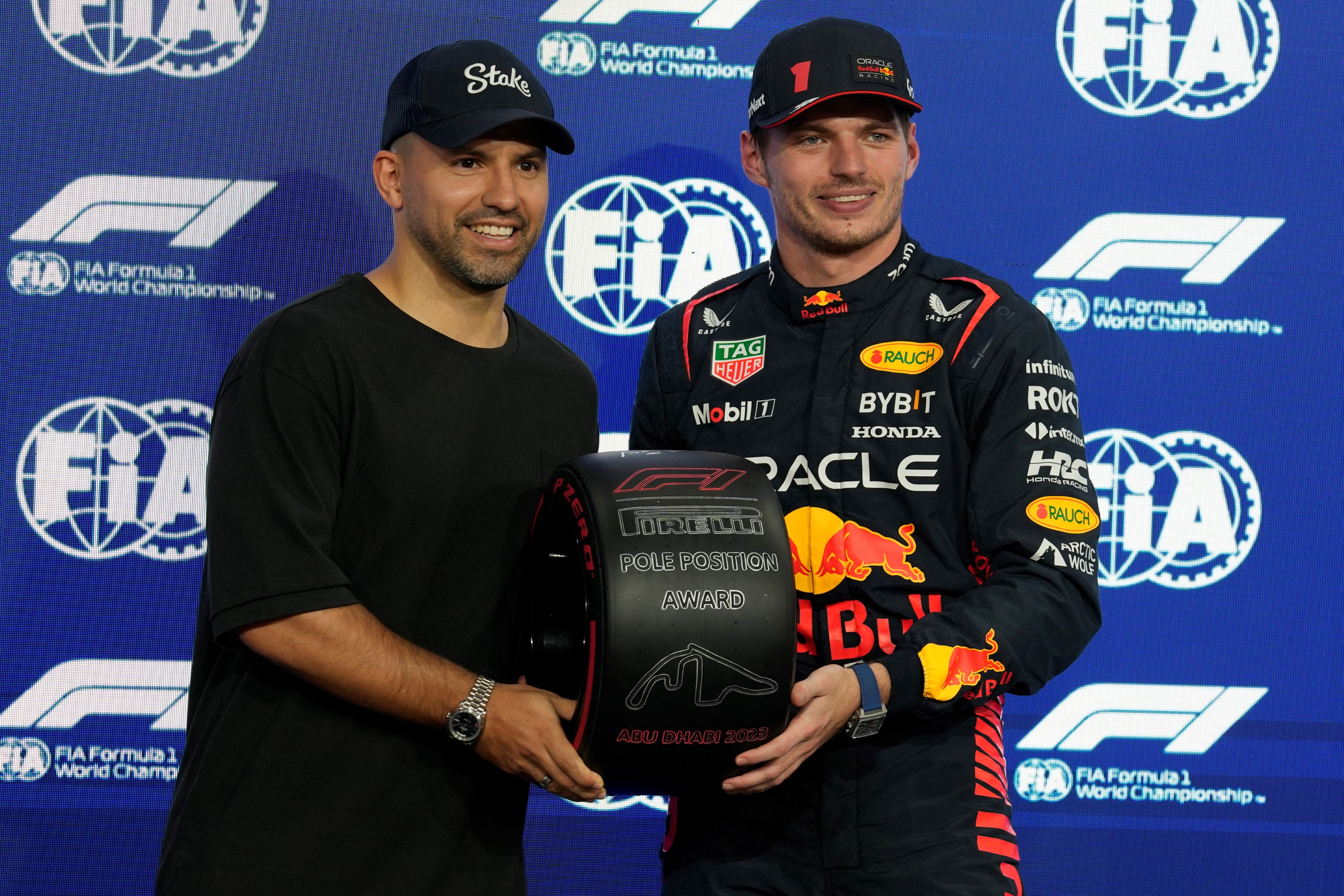 "Kun" Agüero le entrega a Max Verstappen la distinción por haber ganado la pole en la clasificación de la F1 en Abu Dhabi. (AP)