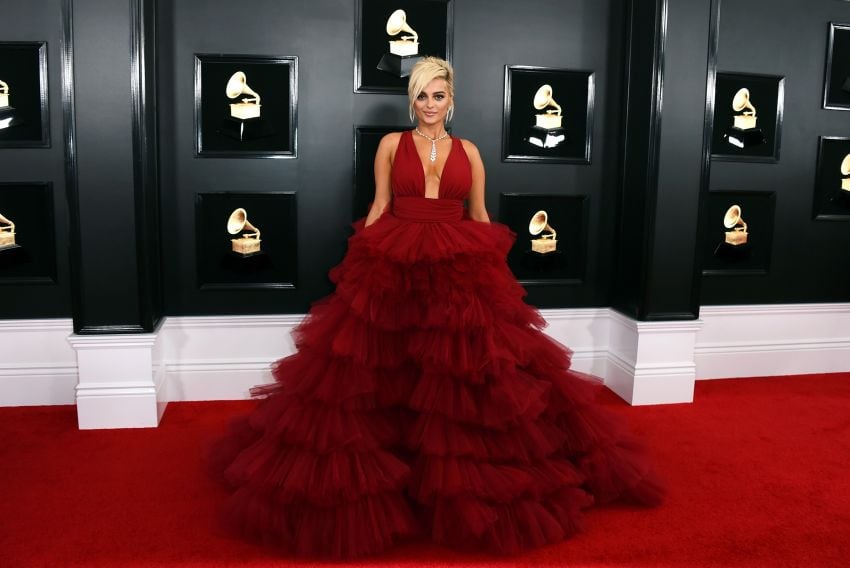 
    Bebe Rexha con un vestido largo de capas de tul rojo.
   