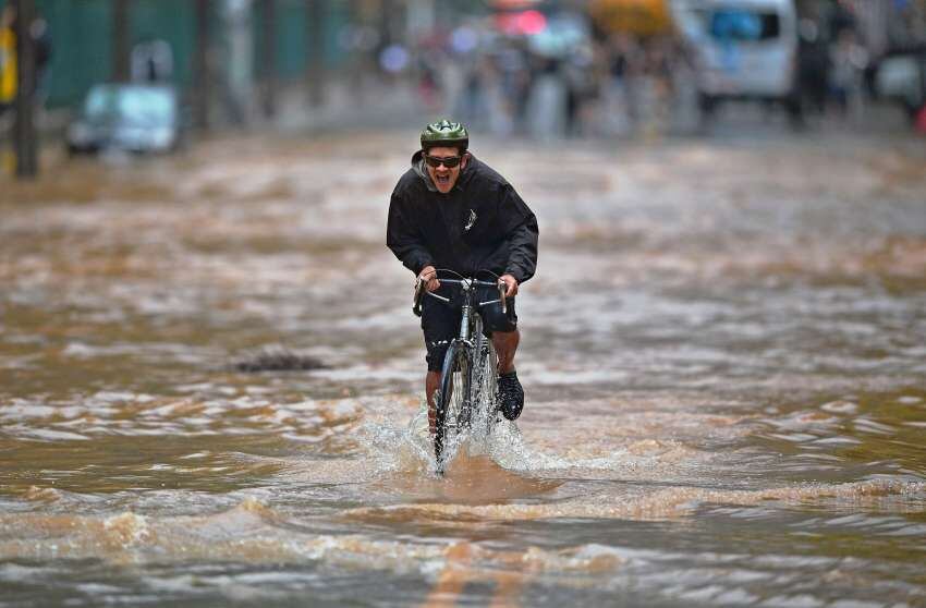 
Nadar en bici. Un ciclista se abre paso en una calle inundada, tras fuertes lluvias en Río de Janeiro. | AFP
   