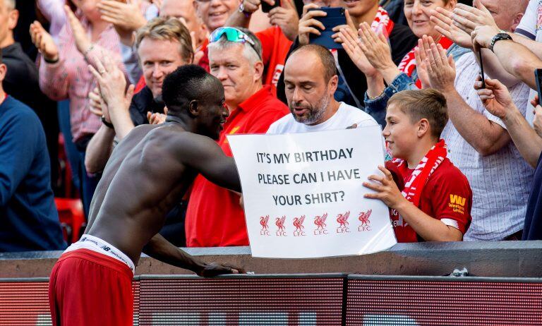 Sadio Mané le regala su camiseta a un joven, en cuyo cartel denota que es su cumpleaños (Foto: EFE).