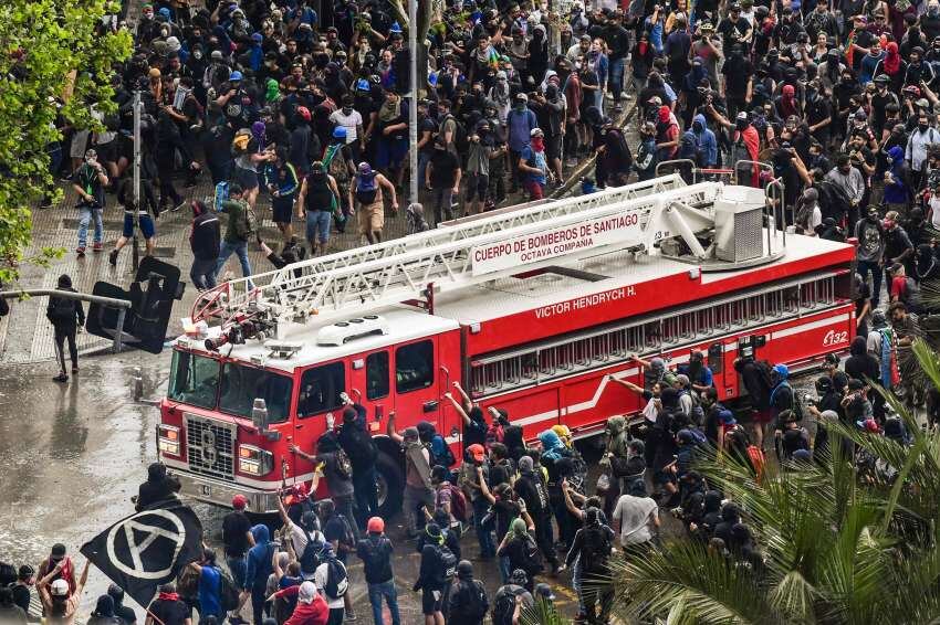 
Los bomberos tuvieron que abrirse paso entre la multitudinaria manifestación  | AFP
   