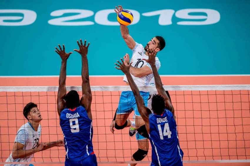 
Foto: AFP | El argentino Nicolas Bruno salta para atacar a los cubanos Livan Osoria y Eduardo Goide durante la final de Voleibol Masculino.
   