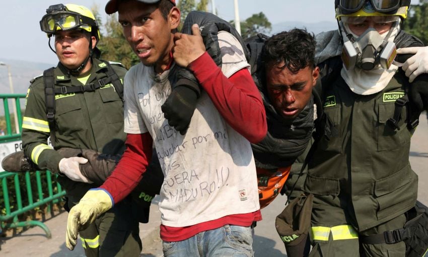 
Violencia. Un joven venezolano herido recibía ayuda ayer en el puente Simón Bolívar.  | AP
   