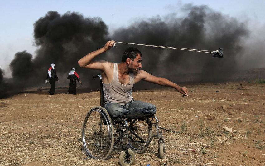 
Foto: AFP | Saber al-Ashkar, de 29 años, lanza piedras durante los enfrentamientos con las fuerzas israelíes a lo largo de la frontera con la franja de Gaza, el 11 de mayo de 2018.
   