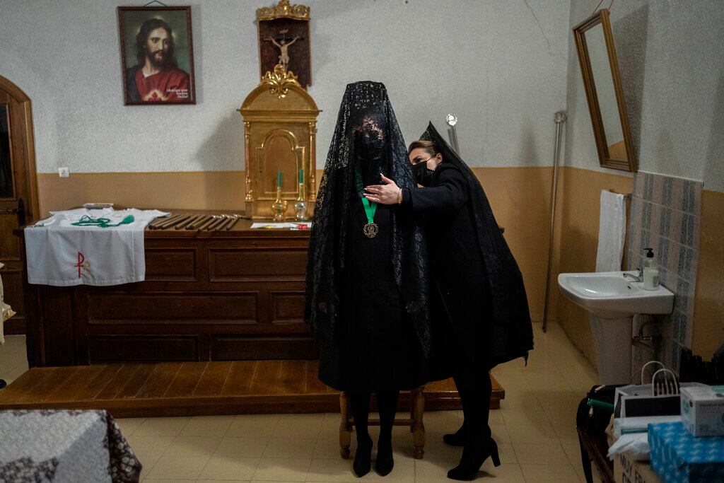 Penitentes de la cofradía de la Virgen de la Esperanza se preparan para una procesión en Zamora, España, el 14 de abril de 2022. (AP Foto/Bernat Armangué)