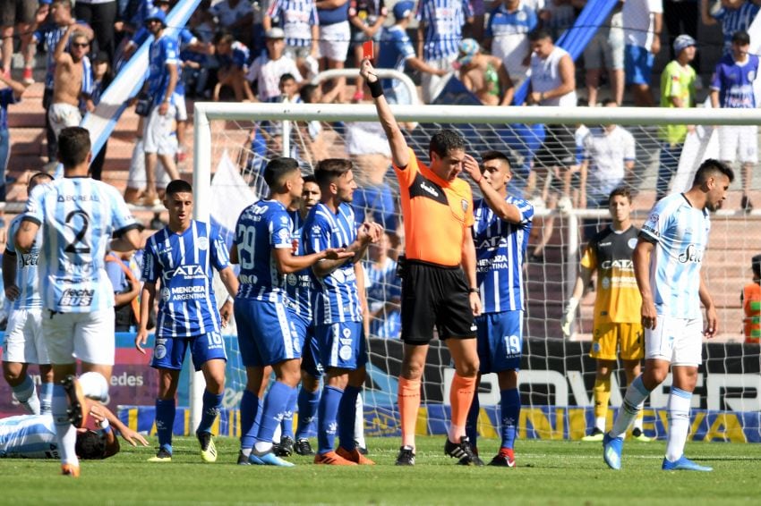 
El juez Echavarría le muestra la roja a Abecasis, mientras Elías y Ramis no entienden nada. El lateral venía de cumplir una sanción. | Marcelo Rolland / Los Andes
   