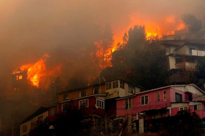 
Las casas arden durante un incendio forestal en la colina Rocuant en Valparaíso | AFP
   