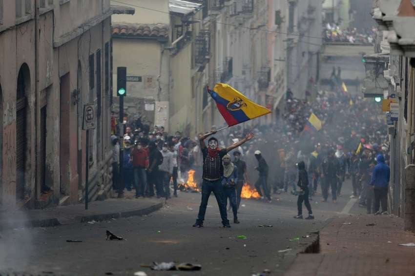 
Foto: AP | Un manifestante ondea una bandera nacional ecuatoriana durante los enfrentamientos en el centro de Quito.
   