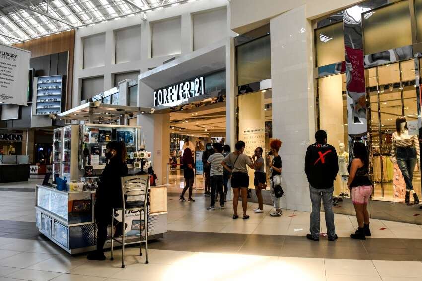 
Los clientes hacen cola afuera de la tienda "Forever 21" dentro de un centro comercial al oeste de Fort Lauderdale, Florida | AFP
   