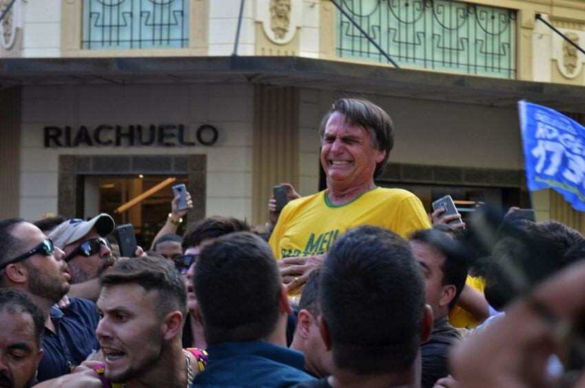 
Foto: AFP | El candidato presidencial brasileño de derecha Jair Bolsonaro gesticula después de ser apuñalado en el estómago durante un mitin de campaña en el estado de Minas Gerais, en el sur de Brasil, el 6 de septiembre de 2018.
   